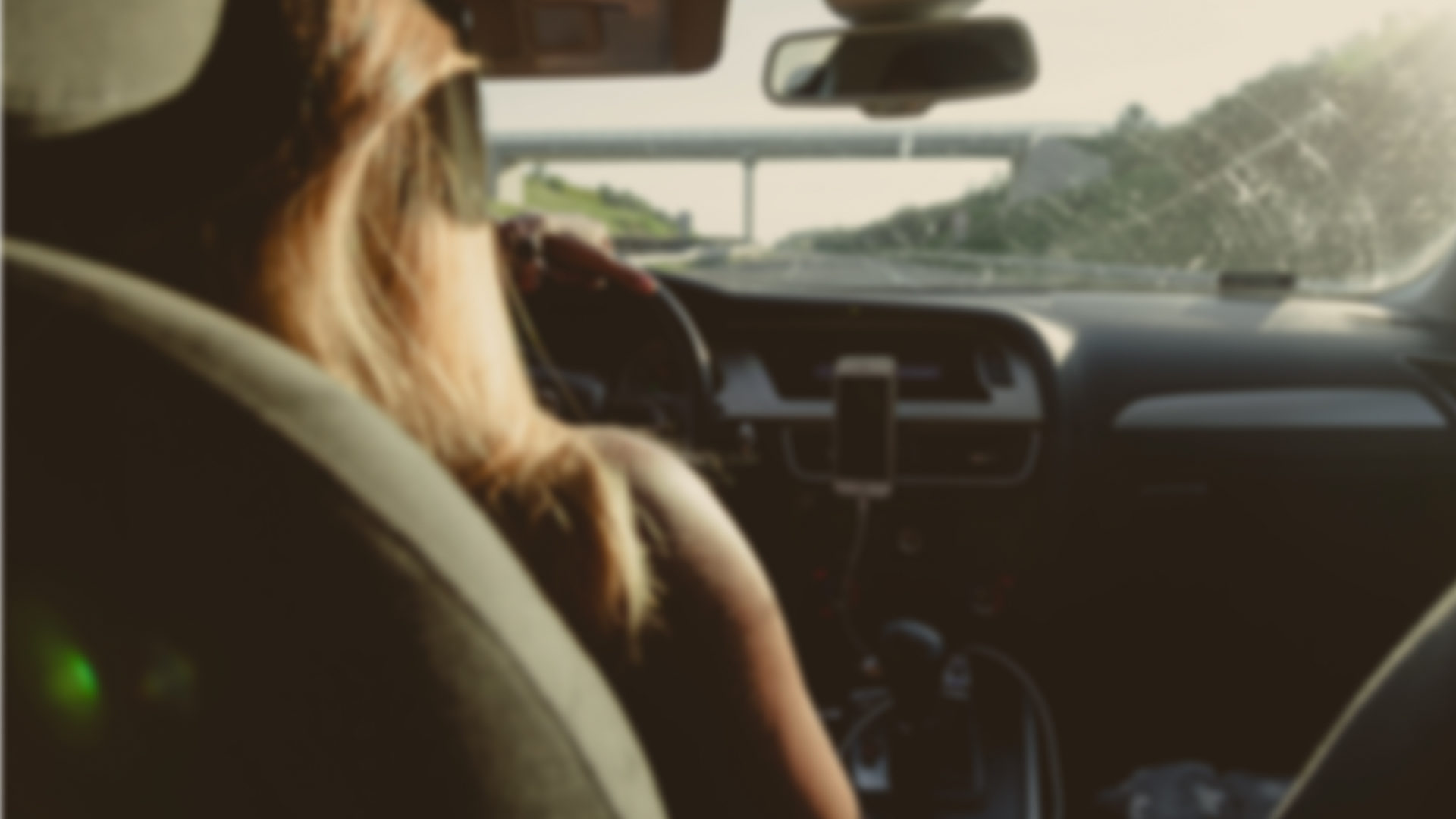 Unfocused photo of a woman driving a vehicle on a freeway