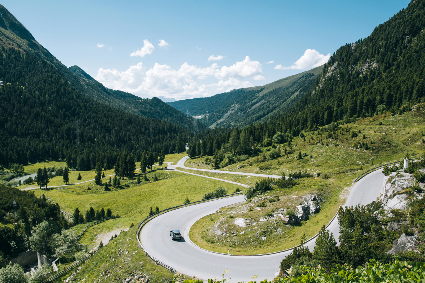 Mountain Valley with Winding Road Mountain valley with green grass, trees, and a winding road